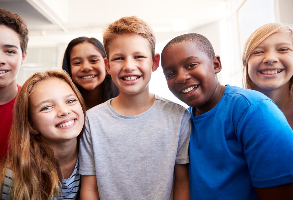 Four school age children smiling 